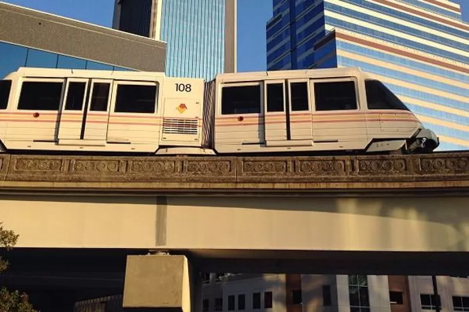 Jacksonville Skyway monorail train passing on elevated rail in front of downtown buildings